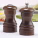 Two walnut salt and pepper shakers on a table.