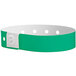 A green and white Carnival King wristband with holes.