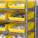 A metal shelving unit with yellow Regency shelf bins holding white objects.