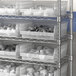 Regency clear plastic shelf bins on a metal shelving unit.