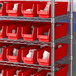 A metal shelving with red Regency shelf bins.