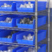 Regency blue shelf bins on a metal shelf.