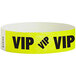 A yellow paper wristband with black text reading "VIP"