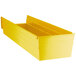 A yellow plastic Regency shelf bin with two compartments.
