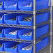 A metal shelf with Regency blue bins holding white and grey objects.