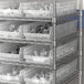 Regency clear plastic shelf bins on a metal shelf.