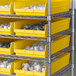 A metal shelving unit with yellow Regency shelf bins.