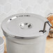 A silver stainless steel Choice 11 Qt. Notched Stainless Steel Inset Cover on a silver pot.