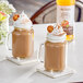 A glass mug filled with brown liquid with whipped cream and a bottle of Monin Zero Calorie Natural Pumpkin Spice Flavoring Syrup.