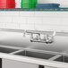 A stainless steel sink with Waterloo wall-mounted faucet and three bins.