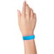 A close-up of a hand with a blue Carnival King wristband.