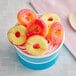A cup of ice cream with Vidal gummy peach rings on top.