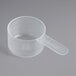 A clear plastic measuring cup with a short handle.
