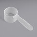 A white plastic measuring cup with a long handle.