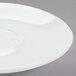 An Arcoroc white saucer with a small rim.