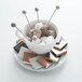 An Arcoroc saucer with a cup of coffee and marshmallow sticks on a table.