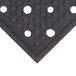 A black rubber safety runner mat with holes in it.