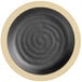 An Acopa Ugoki matte black melamine plate with a medium ivory rim with a spiral design.