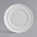 An Acopa Condesa pearl white porcelain plate with a scalloped edge.
