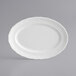 An Acopa Condesa pearl white porcelain platter with a scalloped white rim.