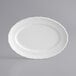 An Acopa Condesa pearl white porcelain platter with a scalloped rim.