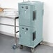 A stack of slate blue Cambro plastic hot food holding cabinets on wheels.