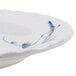 A white melamine plate with blue bamboo designs on the rim.