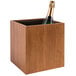 A Room360 rubberwood wine cooler and display stand with a bottle of champagne in it.