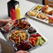 A stainless steel rectangular compartment tray holding food.