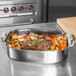 A Vollrath Miramar French oven with roast beef and vegetables in it on a table.