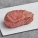 A Rastelli's center cut top sirloin steak on a white surface.