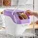 A large white and purple ingredient bin with a flip lid, label, and scoop, used for storing brown sugar.