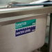 A stainless steel sink with a white sign reading "Sanitizer" above the water line.