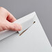 A hand opening a white Lavex Stayflats rigid mailer to reveal a piece of paper.