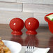 A table set with Fiesta Scarlet China salt and pepper shakers.