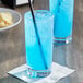 A blue drink with a straw in it.