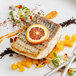 A piece of Wulf's Wild Caught Striped Bass with a slice of orange on top.