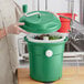 A person using a Garde 2.5 gallon green salad spinner with food inside.