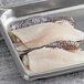 Two Wulf's Black Sea Bass fillet portions on a baking tray.