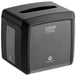 A black Dixie tabletop napkin dispenser box with a clear cover.