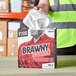 A person holding a box of Brawny Professional tall industrial cleaning towels.