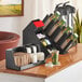 A black plastic countertop coffee organizer station with cups in a holder.