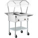 A ServIt stainless steel electric steam table on wheels with a glass sneeze guard.