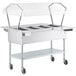 A ServIt open well electric steam table with a clear sneeze guard over hot food pans.