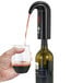 A hand using a Franmara Black Electronic Wine Aerator to pour wine into a glass.