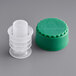 A green plastic bottle cap with a white plastic stopper inside.