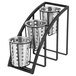A black steel Cal-Mil vertical container rack with three metal containers with holes.