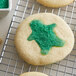 Green sugar cookies with Regal Light Green Sanding Sugar on a cooling rack.