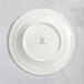 A white RAK Porcelain plate with an embossed crown logo.