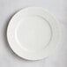 A white RAK Porcelain flat plate with an embossed wavy pattern on the rim.